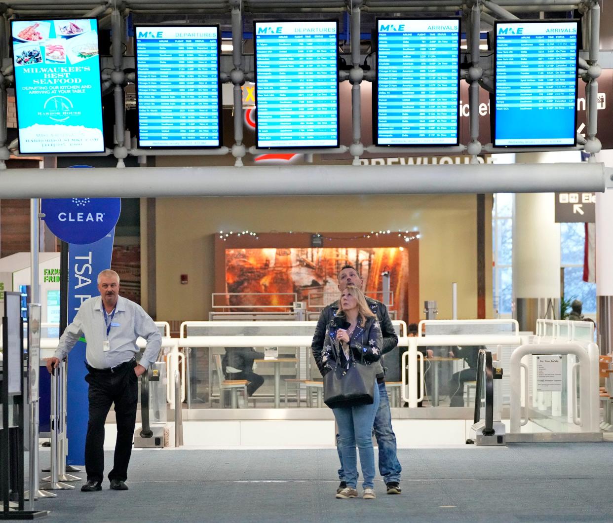 Laurel Walters and her husband John Walters, of Muskego, check the flight board before boarding their flight to Orlando at Milwaukee Mitchell Airport in Milwaukee on Wednesday, Jan. 11, 2023. Domestic air travel was grounded across the United States - including Milwaukee Mitchell International Airport - after a computer outage at the Federal Aviation Administration.