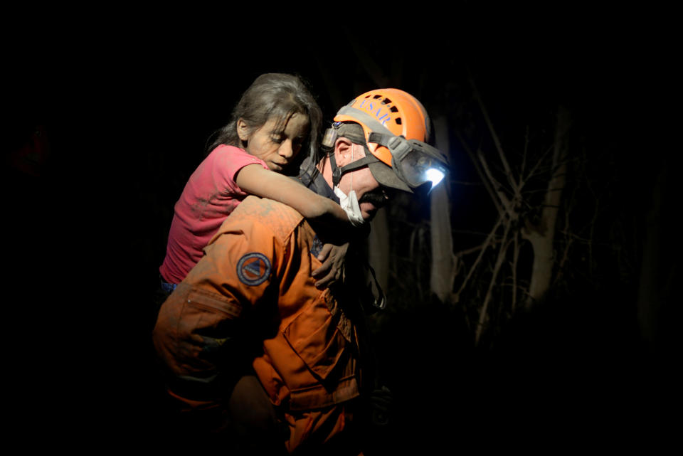 <p>A rescue worker carries a child covered with ash after Fuego volcano erupted violently in El Rodeo, Guatemala June 3, 2018. (Photo: Fabricio Alonzo/Reuters) </p>