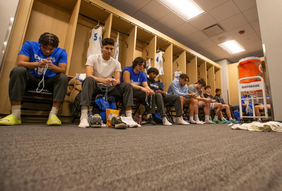 Marian players and coaches pray the Rosary in the locker room before the 3A boys basketball state championship game on Saturday, March 26, 2022, at Gainbridge Fieldhouse in Indianapolis. 