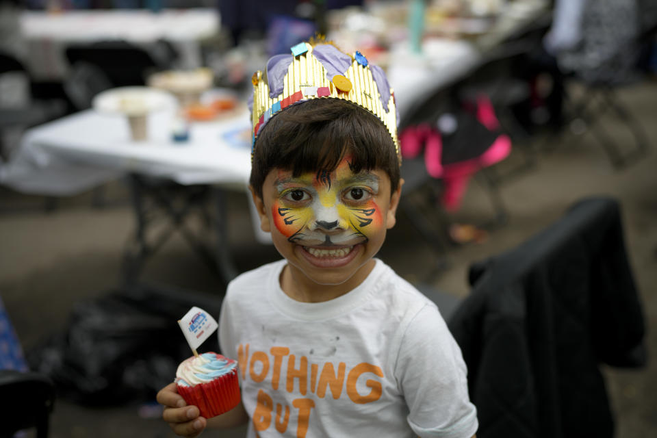 A child holds a cupcake during the Big Lunch celebrations in London's Regent's Park, Sunday, May 7, 2023. Sunday, May 7, 2023. The Big Lunch is part of the weekend of celebrations for the Coronation of King Charles III. (AP Photo/Andreea Alexandru)