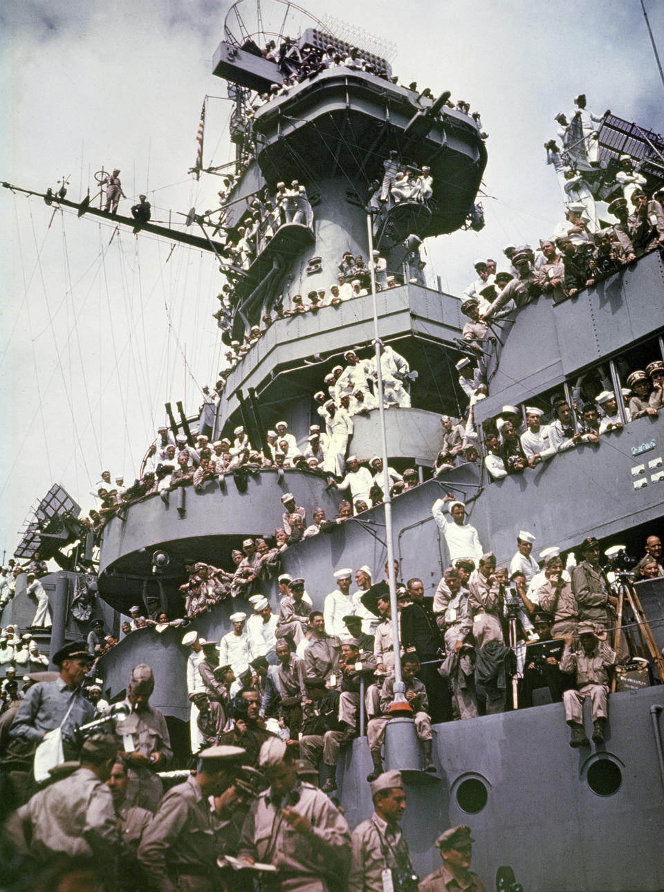 FILE - Servicemen, reporters, and photographers perch on the USS Missouri on Sept. 2, 1945, for the onboard ceremony in which Japan surrendered in Tokyo Bay, ending World War II. Several dozen aging U.S. veterans, including some who were in Tokyo Bay as swarms of warplanes buzzed overhead and nations converged to end World War II, will gather on the battleship in Pearl Harbor in September to mark the 75th anniversary of Japan's surrender, even if it means the vulnerable group may be risking their lives again amid the coronavirus pandemic. (AP Photo, File)