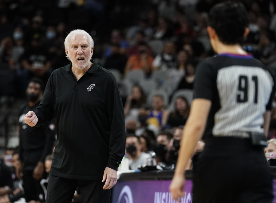 San Antonio Spurs coach Gregg Popovich talks to referee Cheryl Flores during the first half of the team's preseason NBA basketball game against the Houston Rockets, Friday, Oct. 15, 2021, in San Antonio. (AP Photo/Darren Abate)