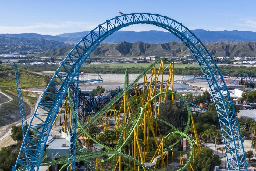 Aerial views of Six Flags Magic Mountain, closed due to the Covid-19 pandemic. A hawk is perched atop the Dive Devil structure near Riddler's Revenge.