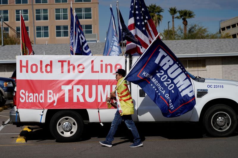 FILE PHOTO: A protestor caries a "Trump 2020" flag as Arizona electors gather to cast their votes for the U.S. presidential election in Phoenix