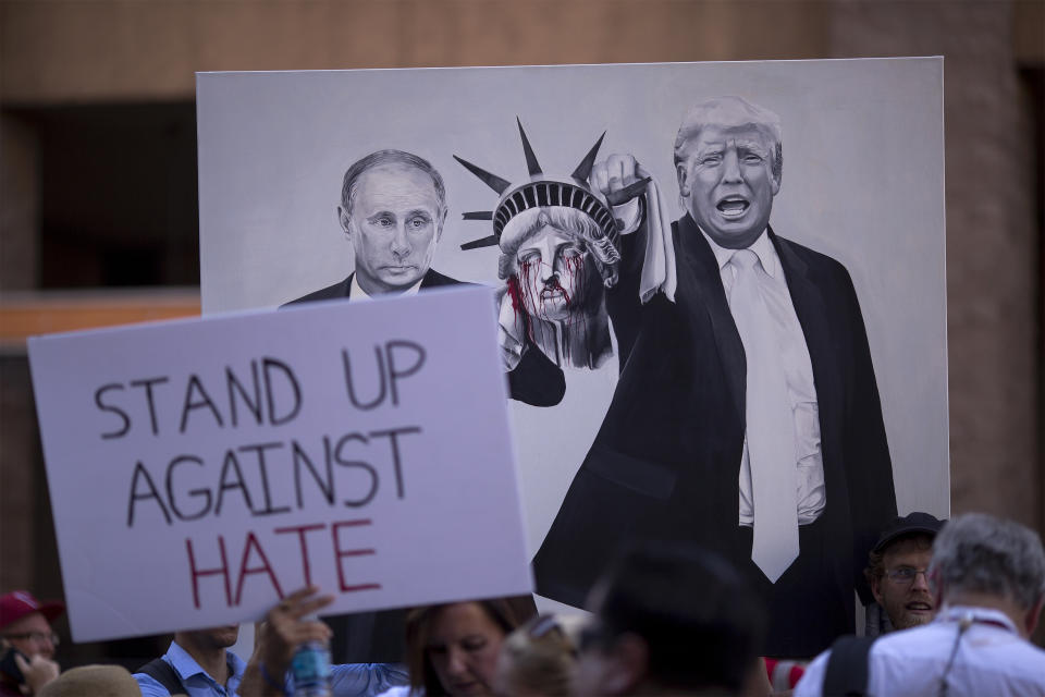 <p>Anti-President Donald Trump demonstrators hold a painting of Russian president Vladimir Putin and Trump outside the Phoenix Convention Center before a rally by Trump on August 22, 2017 in Phoenix, Arizona. (David McNew/Getty Images) </p>