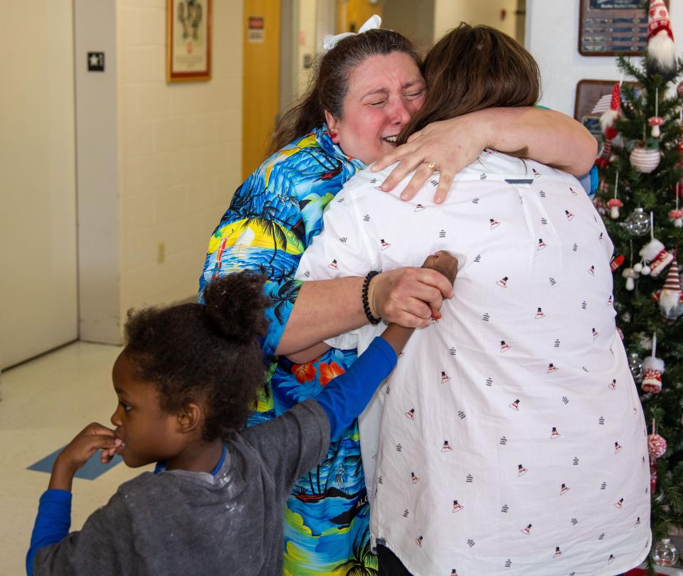 Hammett Bowen Elementary School autism spectrum disorder self contained teacher Jennefer Bachmaier, center, with student Yahkeem Bird in tow, bottom, hugs her daughter Alexandria Armstrong on Friday.