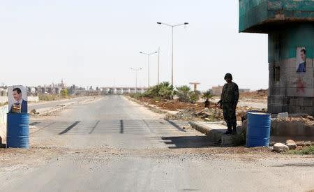 FILE PHOTO: A Syrian soldier stands guard at the Nasib border crossing with Jordan in Deraa, Syria July 7, 2018. REUTERS/ Omar Sanadiki/File Photo