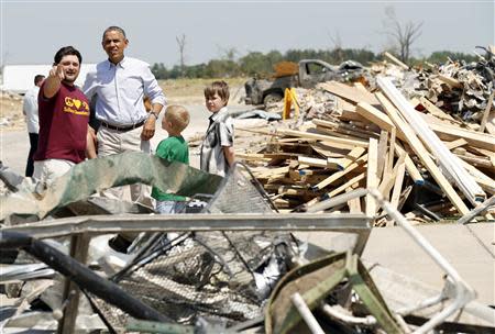 U.S. President Barack Obama talks with Daniel Smith and sons Gabriel Dority (R) and Garrison Dority as he visits the tornado devastated town of Vilonia, Arkansas May 7, 2014. REUTERS/Kevin Lamarque