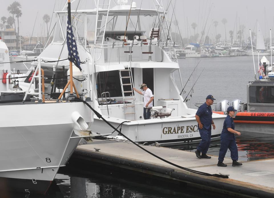 Coast Guard officials leave after talking to the captain of the Grape Escape boat which rescued victims of a boat fire off the Channel Islands, at the US Coast Guard Station Channel Islands in Oxnard, California on September 2, 2019. - A commercial scuba-dive boat sank amid intense flames early off the coast of Southern California and 34 passengers were unaccounted for, the US Coast Guard said. Five Conception crew members were awake and jumped into the water when flames burst out around 3:15 am (1015 GMT), Coast Guard Captain Monica Rochester told reporters in a televised briefing. She said 34 people -- not the 33 reported earlier by the Coast Guard -- were unaccounted for when the Conception sank 20 yards (meters) offshore, leaving only its bow exposed. (Photo by Mark RALSTON / AFP)        (Photo credit should read MARK RALSTON/AFP/Getty Images)