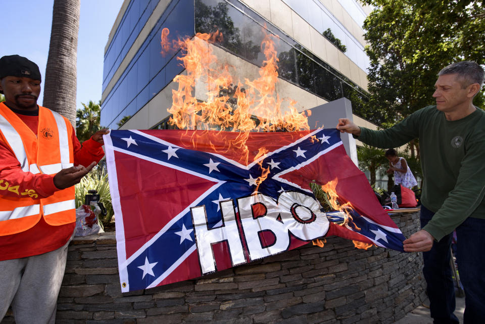 Members of Roofers Local 36 stages a protest in front of HBO's Santa Monica offices on Aug. 12. The union's business manager Cliff Smith, right, and member Iyzayra Scott, left, burned&nbsp;a Confederate flag emblazoned with the network's&nbsp;logo in protest of the&nbsp;planned&nbsp;series "Confederate." (Photo: NurPhoto via Getty Images)