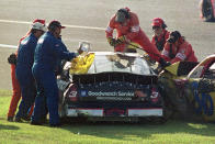 FILE - In this Feb. 18, 2001, file photo, workers try to remove Dale Earnhardt (3) from his vehicle after a crash also involving Ken Schrader (36) during the NASCAR Daytona 500 auto race at the Daytona International Speedway in Daytona Beach, Fla. Since its widespread introduction two decades ago, sparked by the stunning death of seven-time NASCAR champion Dale Earnhardt on the final lap of the 2001 Daytona 500, the HANS device has become a standard piece of safety equipment in pretty much all forms of racing. (AP Photo/Greg Suvino, File)