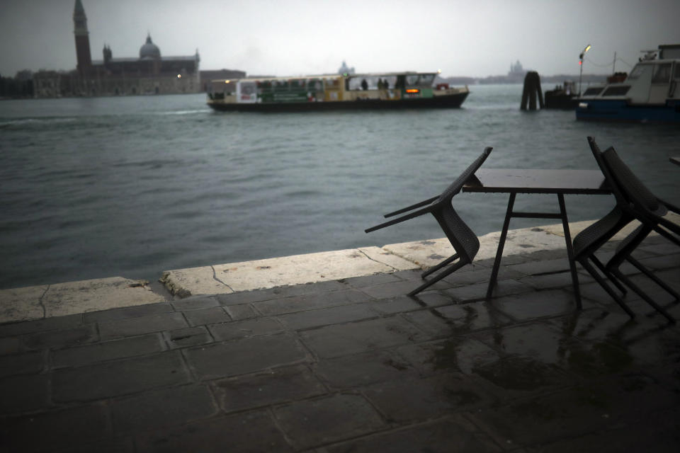 A ferry sails along the lagoon on a rainy day in Venice, Sunday, March 1, 2020. Italian tourism officials are worrying a new virus could do more damage to their industry than the Sept. 11 terror attacks. (AP Photo/Francisco Seco)