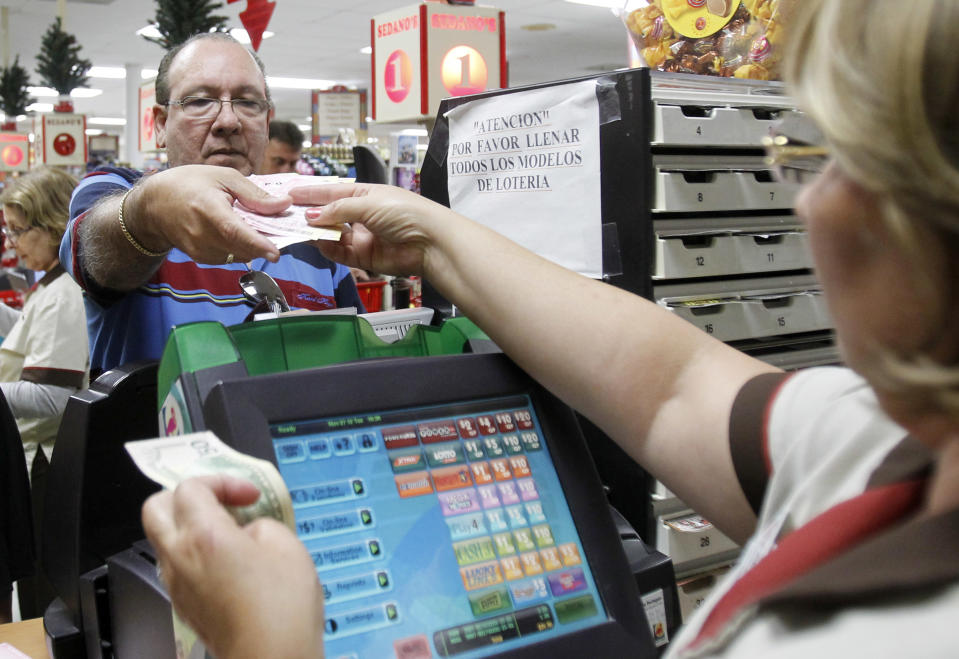 Maria Diaz, right, sells a customer Powerball tickets at a local supermarket in Hialeah, Fla.,Tuesday, Nov. 27, 2012. There has been no Powerball winner since Oct. 6, and the jackpot already has reached a record level for the game. Already over $500 million, it is the second-highest jackpot in lottery history, behind only the $656 million Mega Millions prize in March. (AP Photo/Alan Diaz)