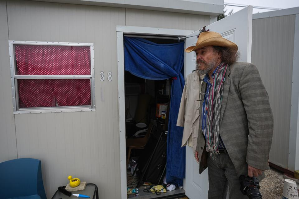 Donald "Hippie" Montgomery opens the door to his cabin in the Esperanza Community in southeastern Travis County. The site operated by the Other Ones Foundation offers shelter and support services for people experiencing homelessness.