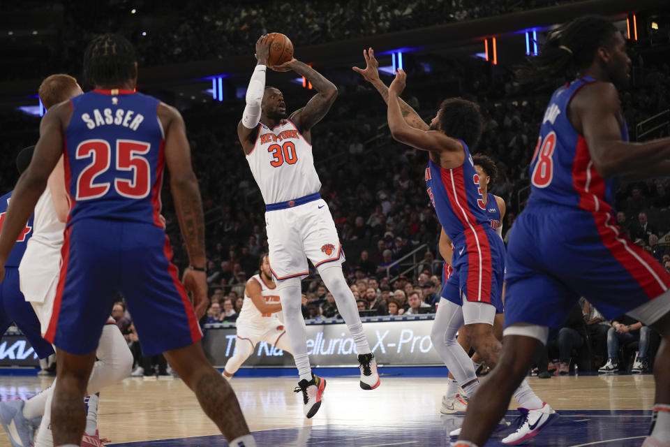 New York Knicks' Julius Randle (30), center, puts up a shot over Detroit Pistons defenders during the first half of an NBA basketball game, Thursday, Nov. 30, 2023, in New York. (AP Photo/Seth Wenig)