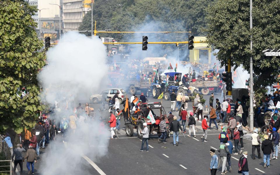 NEW DELHI, INDIA - JANUARY 26: Tear gas fired by police to stop protesting farmers on tractors after they entered the city on Republic Day at ITO on January 26, 2021 in New Delhi, India. Major scenes of chaos and mayhem at Delhi borders as groups of farmers allegedly broke barricades and police check posts and entered the national capital before permitted timings. Police used tear gas at Delhi's Mukarba Chowk to bring the groups under control. Clashes were also reported at ITO, Akshardham. Several rounds of talks between the government and protesting farmers have failed to resolve the impasse over the three farm laws. The kisan bodies, which have been protesting in the national capital for almost two months, demanding the repeal of three contentious farm laws have remained firm on their decision to hold a tractor rally on the occasion of Republic Day.(Photo by Arvind Yadav/Hindustan Times via Getty Images)