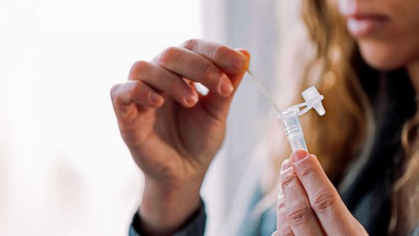 PHOTO: FILE - A woman placing swab into the antigen test extraction tube (Cris Cantã³n/Getty Images, FILE)