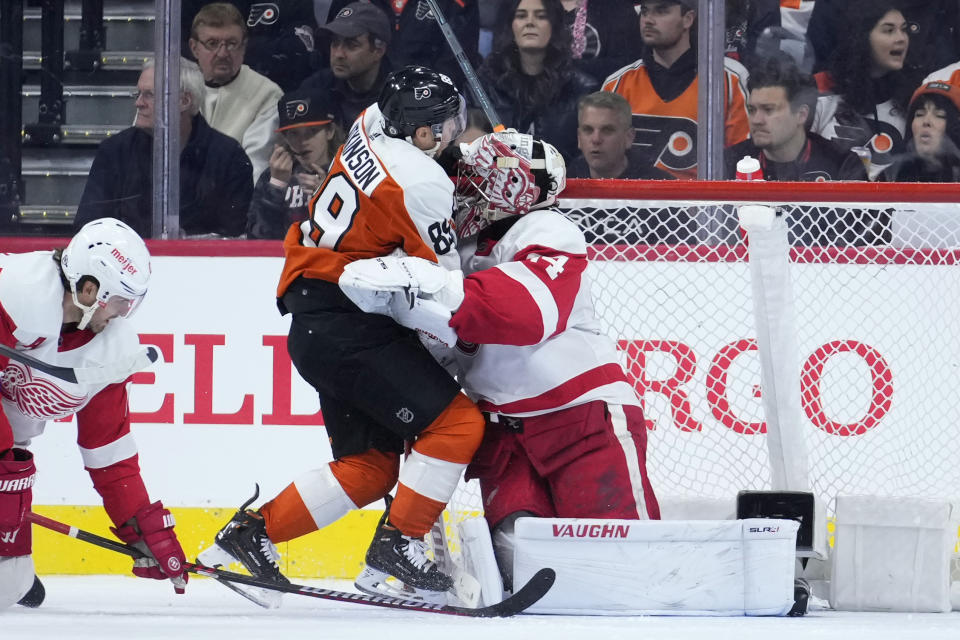 Philadelphia Flyers' Cam Atkinson (89) collides with Detroit Red Wings' Alex Lyon (34) during the first period of an NHL hockey game, Saturday, Dec. 16, 2023, in Philadelphia. (AP Photo/Matt Slocum)