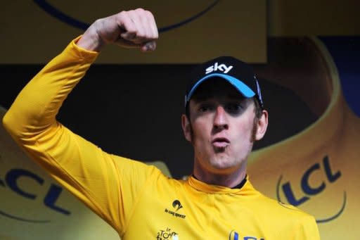 Stage winner, overall leader's yellow jersey British Bradley Wiggins, celebrates on the podium at the end of the 41.5 km individual time-trial and ninth stage of the 2012 Tour de France cycling race starting in Arc-et-Senans and finishing in Besancon, eastern France