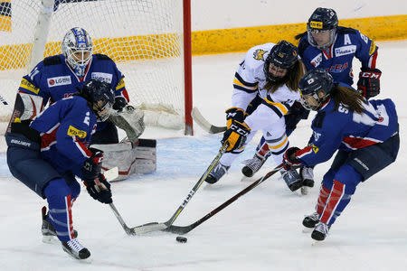 South Korean players take the puck away from Quinnipiac University's Taylor House during an Olympic preparation, women's ice hockey game for South Korea in Hamden, Connecticut, U.S., December 28, 2017. Picture taken December 28, 2017. REUTERS/Brian Snyder