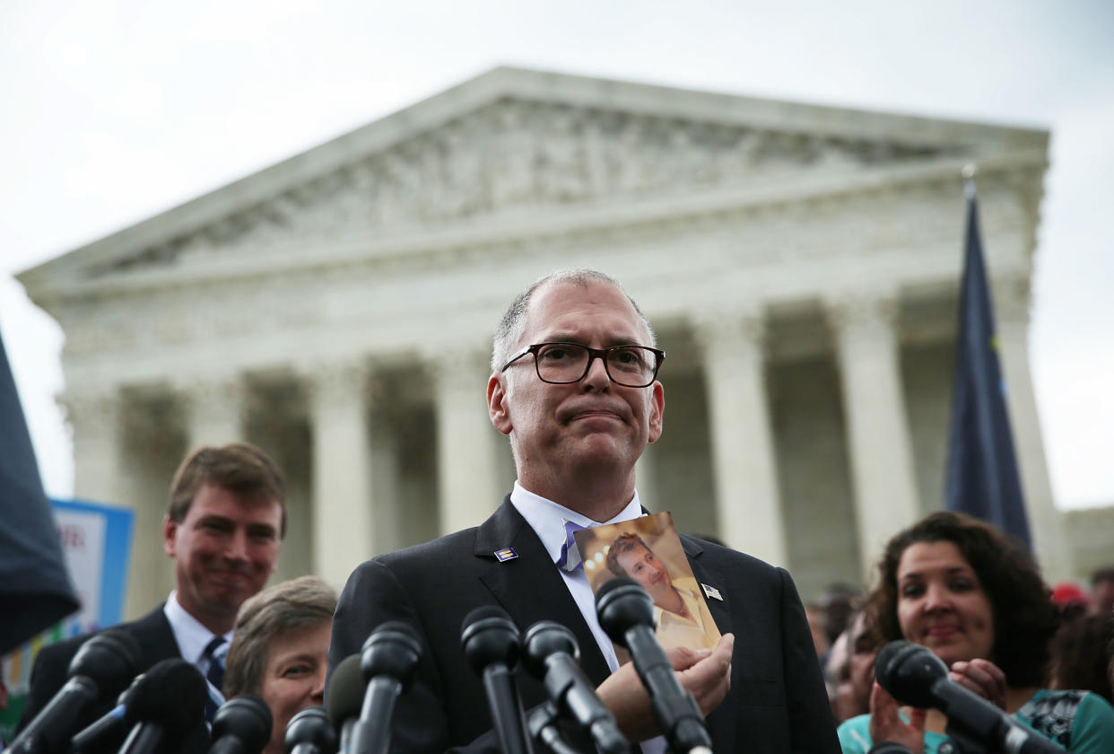 Jim Obergefell holds a photo of his late husband, John Arthur, as he speaks to members of the media outside the Supreme Court.