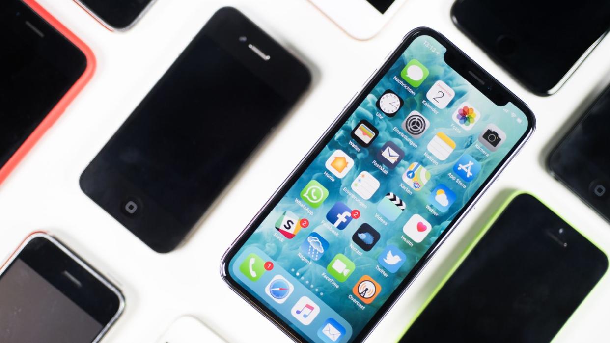 Ein iPhone X liegt neben iPhones anderer Generationen auf einem Tisch. Foto: Lino Mirgeler