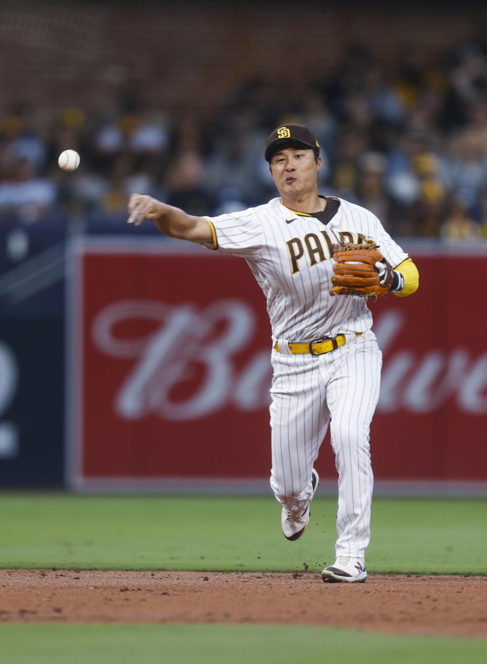 San Diego Padres shortstop Ha-Seong Kim throws to first for the out on Milwaukee Brewers' Andrew McCutchen during the third inning of a baseball game Tuesday, May 24, 2022, in San Diego. (AP Photo/Mike McGinnis)