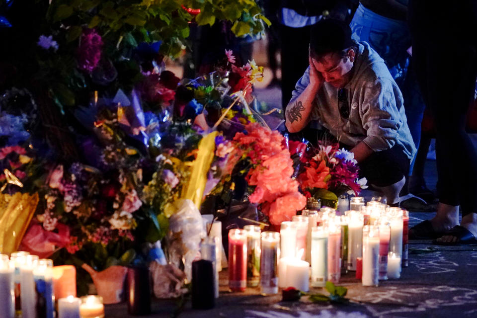 A person pays his respects outside the scene of a shooting at a supermarket, in Buffalo, N.Y., Sunday, May 15, 2022. (AP Photo/Matt Rourke)