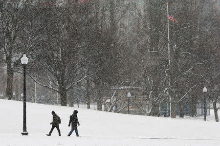 Pedestrians walk through Boston Common during a winter snow storm in Boston, Massachusetts, U.S., January 17, 2018. REUTERS/Brian Snyder