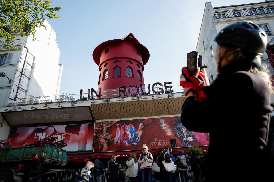 People take pictures of the landmark red windmill atop the Moulin Rouge, Paris' most famous cabaret club, after its sails fell off during the night in Paris, France, April 25, 2024. / Credit: Benoit Tessier/REUTERS