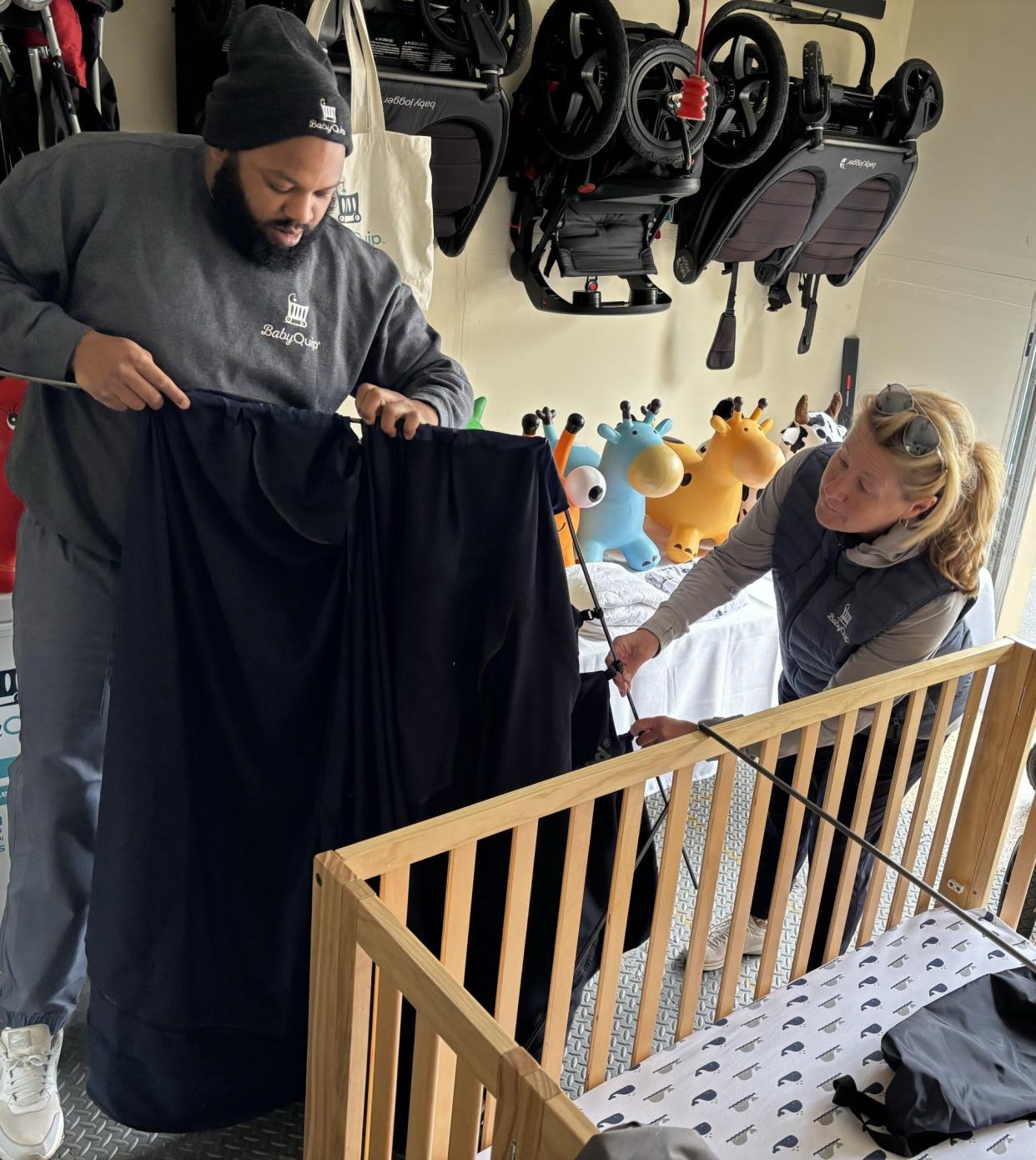 Stephanie Lamb, right, the owner of BabyQuip in Wells, Maine, works with deliveryman Al Harrison to assemble a crib for a local client in March of 2024.
