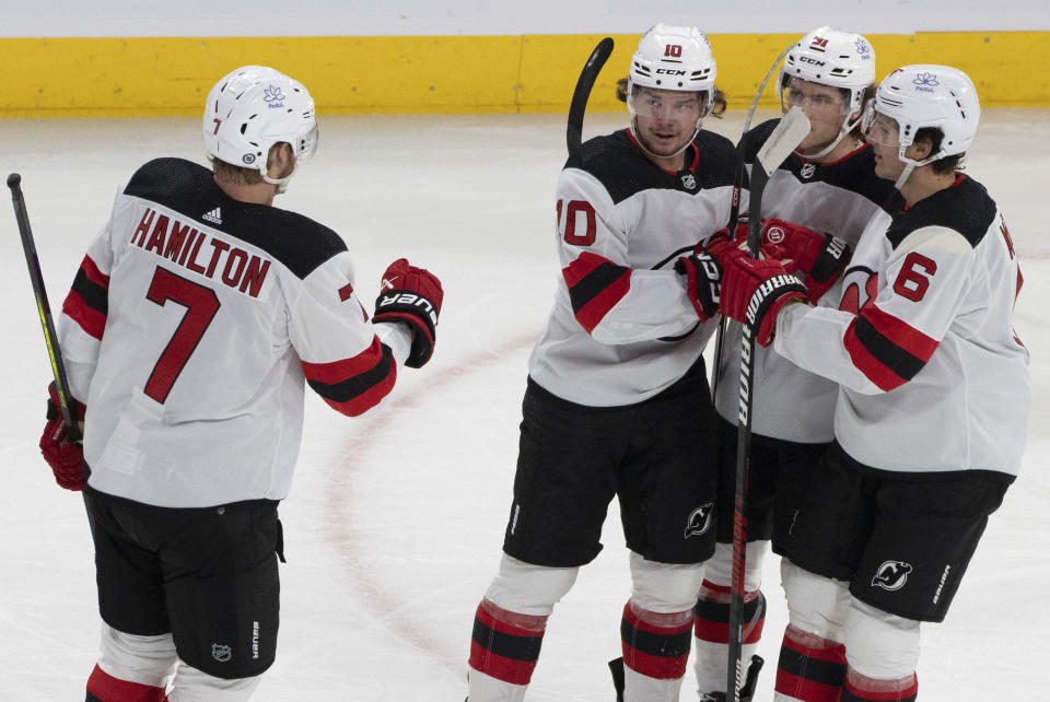 New Jersey Devils' Alexander Holtz (10) celebrates his goal against the Montreal Canadiens with Dougie Hamilton (7), Dawson Mercer (91) and John Marino (6) during the first period of an NHL hockey game Tuesday, Oct. 24. 2023, in Montreal. (Christinne Muschi/The Canadian Press via AP)