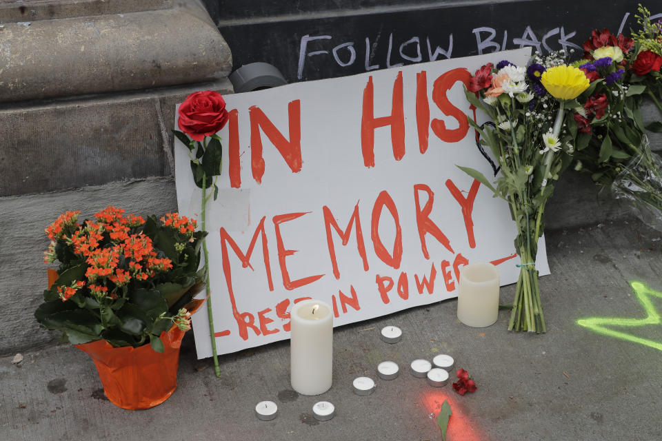 A sign that reads "In his Memory Rest in Power," is displayed at a growing memorial to a person named Lorenzo, Saturday, June 20, 2020, at the intersection of 10th Ave. and Pine St. near the Capitol Hill Occupied Protest zone in Seattle. A pre-dawn shooting near the area left one person dead and critically injured another person, authorities said Saturday. The area has been occupied by protesters after Seattle Police pulled back from several blocks of the city's Capitol Hill neighborhood near the Police Department's East Precinct building. (AP Photo/Ted S. Warren)