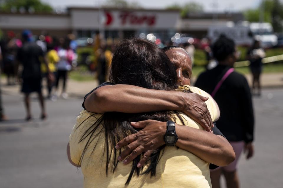 Two women hug outside a Tops Friendly Market store