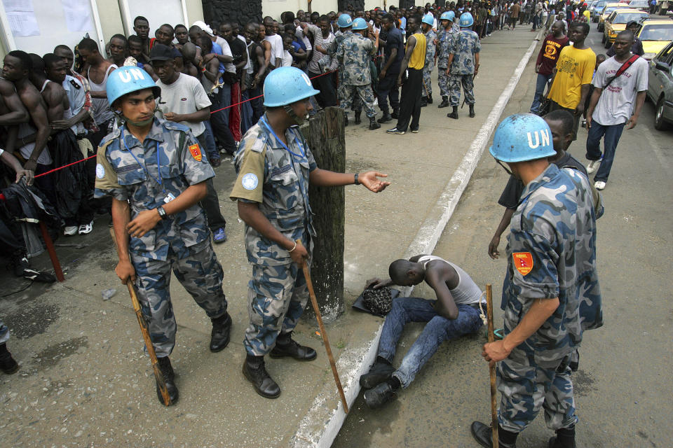 FILE - Nepalese UN peacekeepers try to contain Liberian men, some of whom have lined up for two days to register for the new Liberian Army in Monrovia, Liberia, on Jan. 19, 2006. The United Nations Peacekeeping efforts is under resourced as its $5.5 billion budget for worldwide operations is less than the New York Police Department's $6.1 billion budget, even though it has 30,000 more personnel, the UN Under-Secretary General, Peace Operations Jean-Pierre Lacroix said Wednesday, Dec. 6, 2023 at a two-day UN Peacekeeping Ministerial Meeting in Accra, Ghana. (AP Photo/Jerome Delay, File)