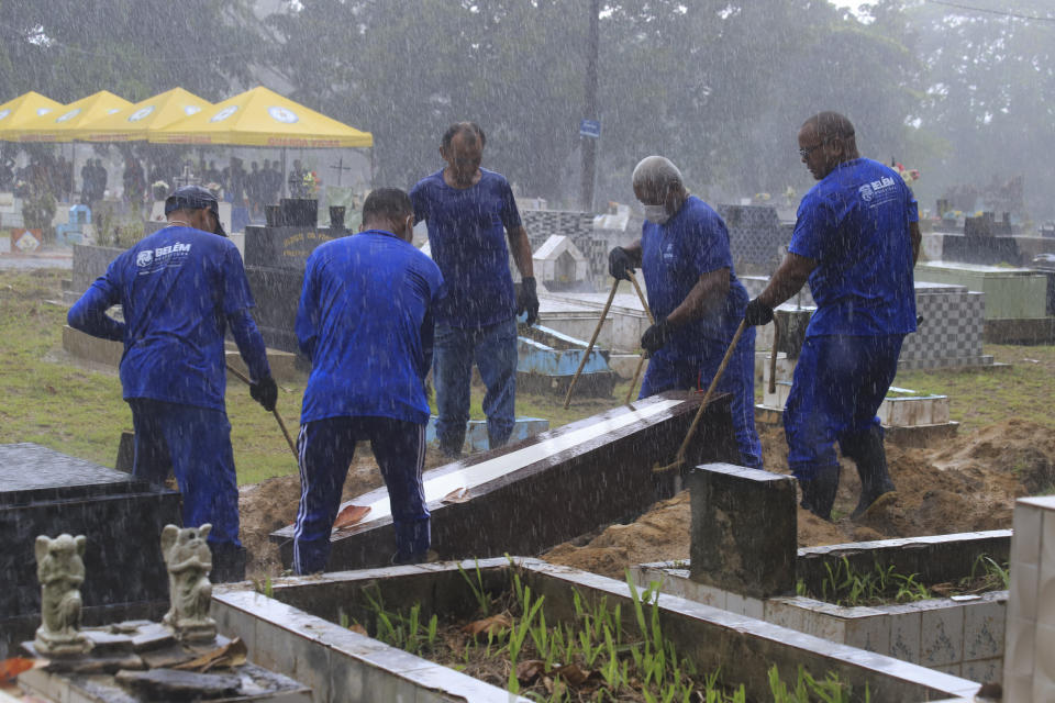 Cemetery workers carry the coffin that contains the remains of an unidentified migrant, at the Sao Jorge cemetery, in Belem, Para state, Brazil, Thursday, April 25, 2024. The bodies of nine migrants found on an African boat off the northern coast of Brazil's Amazon region were buried Thursday with a solemn ceremony. (AP Photo/Paulo Santos)