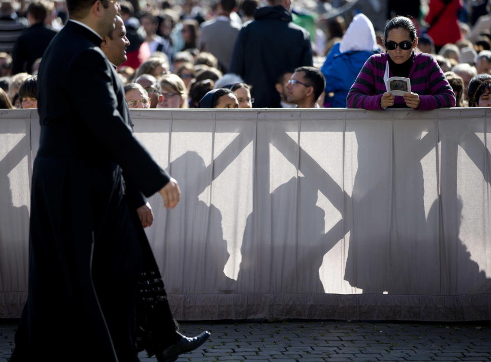 A woman reads the booklet of the Mass ahead of Pope Francis' Easter Sunday Mass in St. Peter's Square at the Vatican Sunday, April 20, 2014. Even before Mass began in late morning, more than 100,000 tourist, Romans and pilgrims, young and old, had turned out for the celebration. Easter Sunday is the culmination of Holy Week, and the day which marks the Christian belief that Jesus rose from the dead after his crucifixion. (AP Photo/Andrew Medichini)