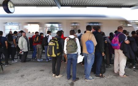 Migrants wait to board a train at a station in Freilassing, Germany September 17, 2015. REUTERS/Michaela Rehle