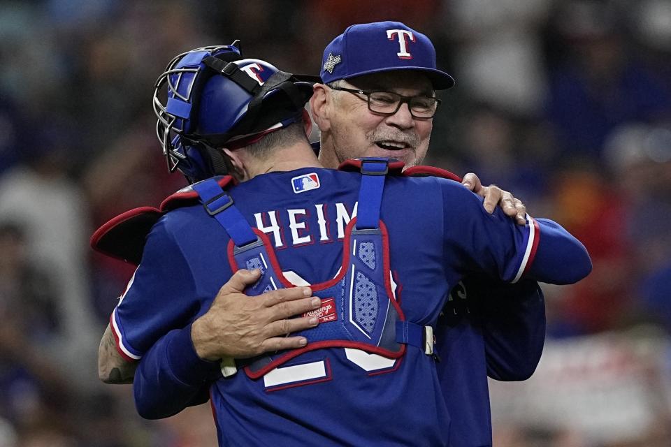 Texas Rangers manager Bruce Bochy huge Jonah Heim after Game 7 of the baseball AL Championship Series against the Houston Astros Monday, Oct. 23, 2023, in Houston. The Rangers won 11-4 to win the series 4-3. (AP Photo/David J. Phillip)