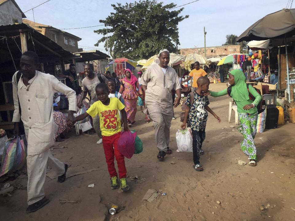 People walk to the ferry heading towards Senegal in Gambia's capital Banjul Tuesday Jan. 17, 2017. Gambia's President Yahya Jammeh declared a state of emergency just two days before he is supposed to cede power after losing elections last month to President-elect Adama Barrow in the December 2016 election. Barrow is vowing to take power Thursday Jan. 19, despite Jammeh's refusal to leave. (AP Photo)