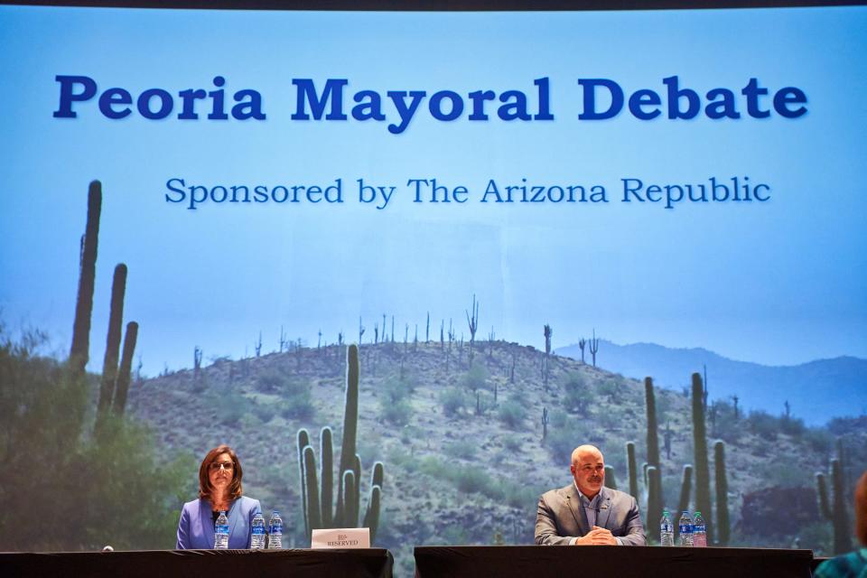 The candidates for Peoria mayor, Bridget Binsbacher (left) and Jason Beck, sit on stage as the Peoria Mayoral Debate begins at Arizona Broadway Theatre in Peoria on Oct. 5, 2022.