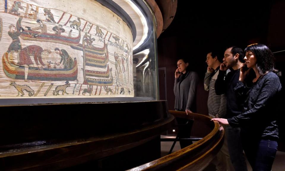 Visitors stand in front of the Bayeux tapestry at the Bayeux museum, France.