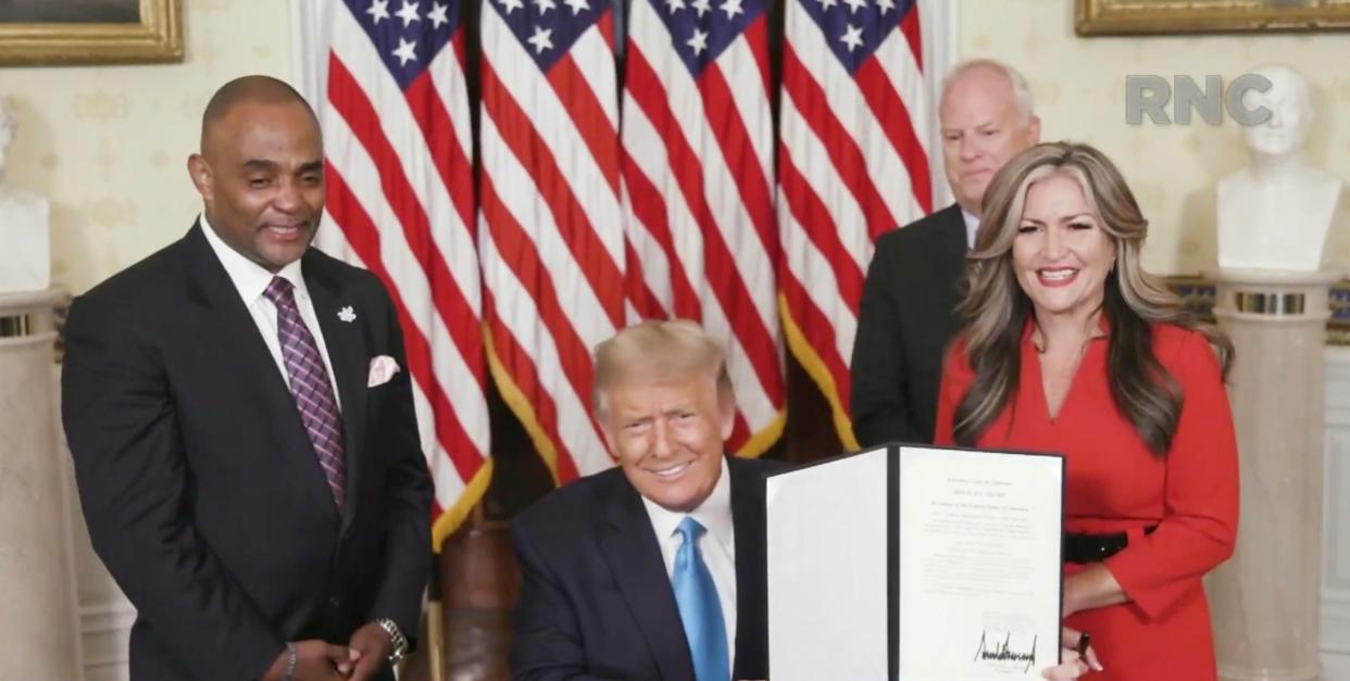 Jon Ponder (L), a convicted bank robber and founder of Hope for Prisoners, his wife Jamie Ponder and former FBI agent Richard Beasley look on as Donald Trump signs a document granting clemency to Ponder during the Republican National Convention: Photo Courtesy of the Committee