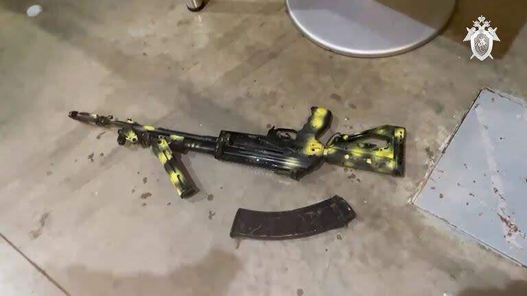 Un rifle de asalto Kalashnikov yace en el suelo mientras investigadores del Comité de Investigación de Rusia junto con las unidades operativas del Ministerio del Interior y el FSB, trabaja en la escena después del ataque 