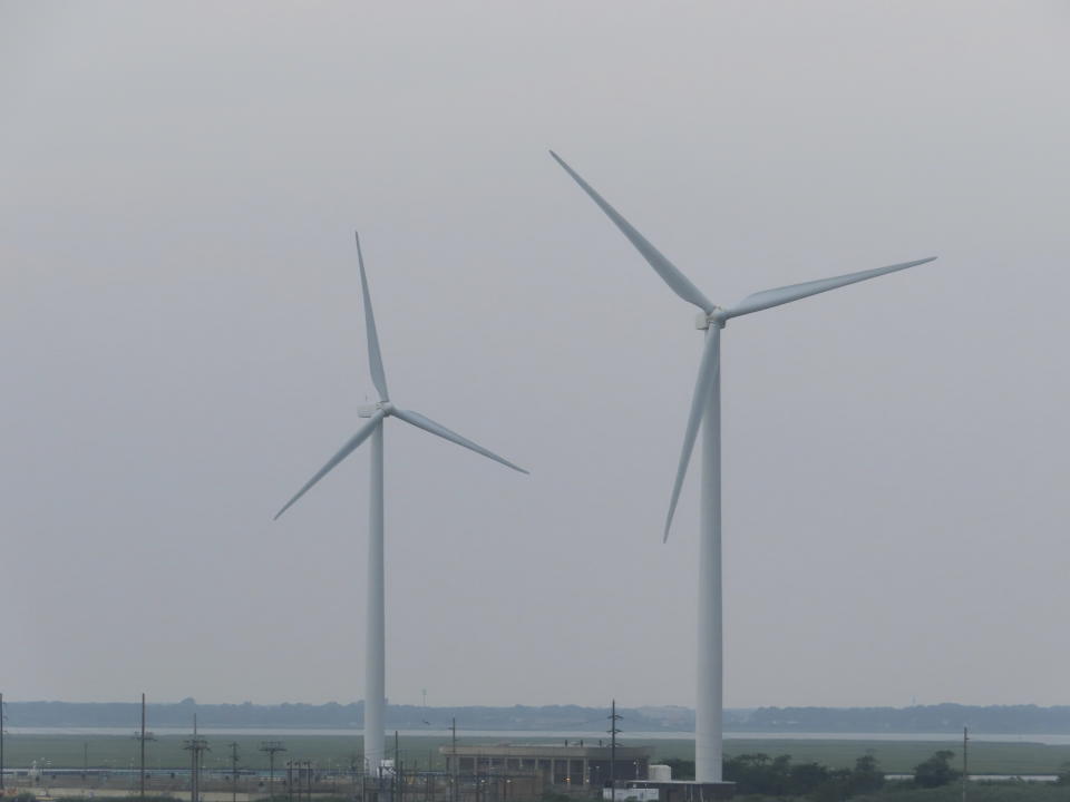 Land-based wind turbines turn in Atlantic City, N.J. on July 20, 2023. On Oct. 2, 2023, New York based Attentive Energy said it plans to build a wind energy farm 42 miles off the coast of Seaside Heights, N.J., the farthest offshore of the seven wind projects publicly proposed for New Jersey and among the farthest offshore on the U.S. East Coast. (AP Photo/Wayne Parry)