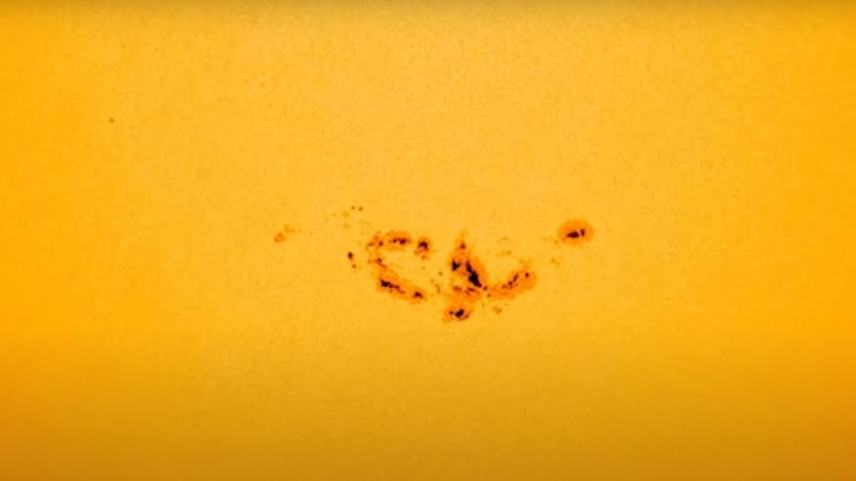 a group of black dots against a mottled orange and yellow background