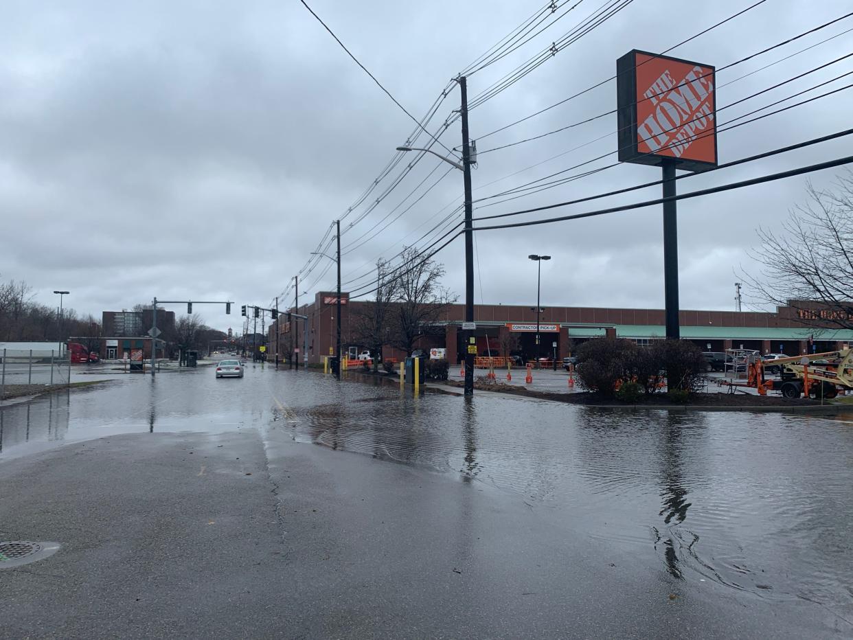 A car is stuck on Charles Street after the nearby West River overflowed its banks amid heavy rain early Saturday morning, flooding the street and the parking lot of Home Depot.
