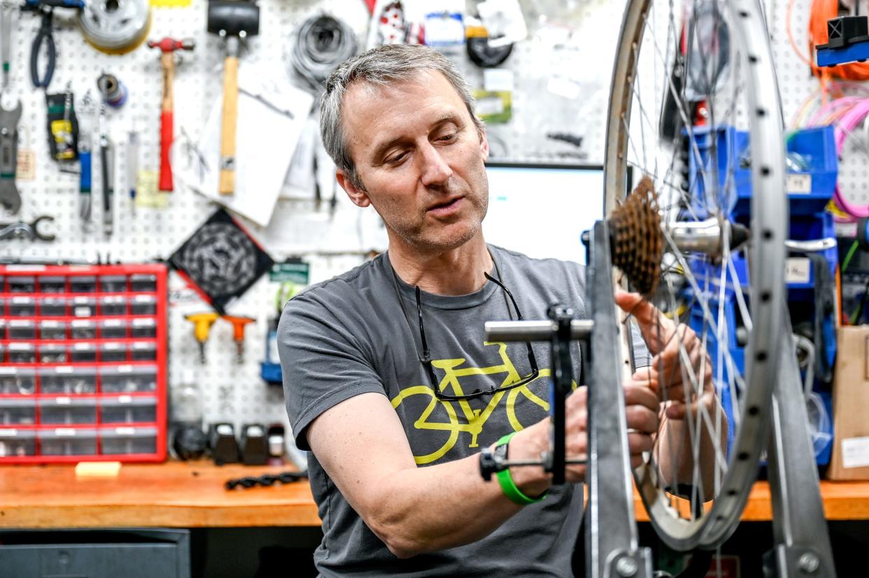 Tim Potter, manager of the MSU Bikes Service Center, works on bicycle rim on Monday, May 9, 2022, at the shop in East Lansing. Potter is one of the organizers for the Greater Lansing 2022 Ride of Silence.