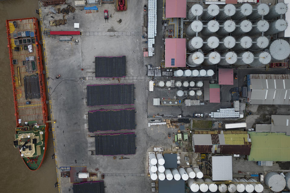 A supply ship, left, waits to be loaded on the Demerara River in Georgetown, Guyana, Tuesday, April 11, 2023. The supply ship ferries to and from ExxonMobil's oil tanker platform that drills for oil in the sea. (AP Photo/Matias Delacroix)