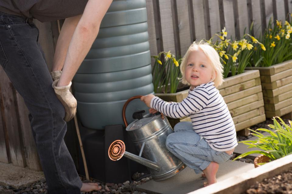 Young child using a water butt